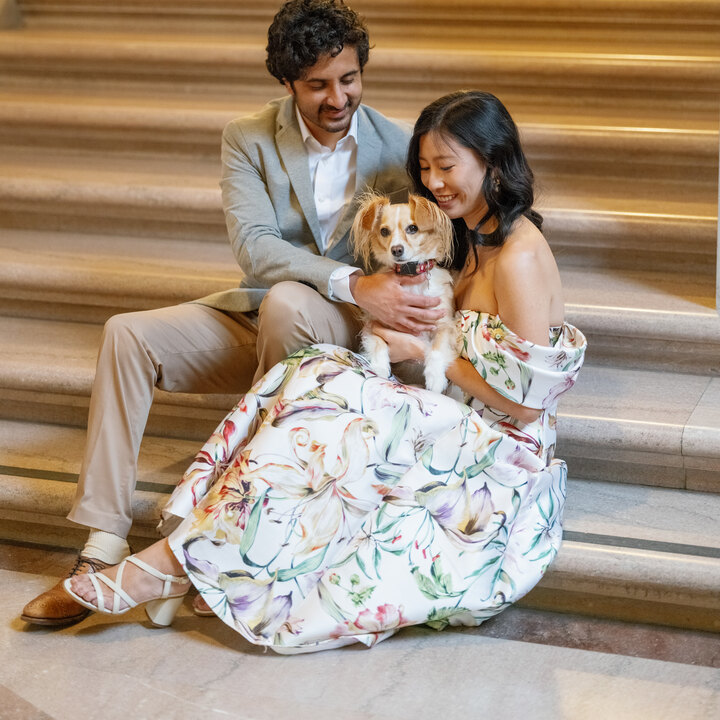 Emily and her partner with their dog on the City Hall staircase